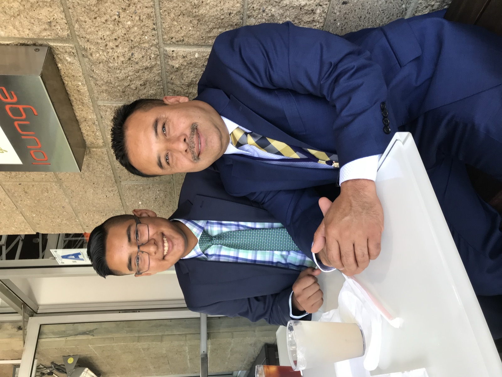 Andrew Orozco as a teenager with his father Servando, both in suits, seated at a table