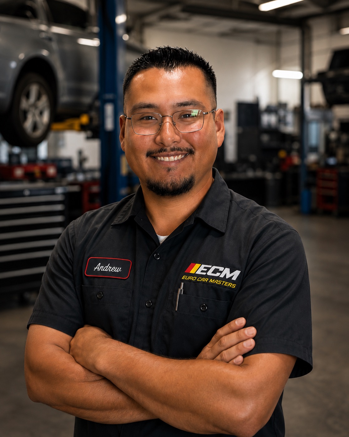 Andrew Orozco in a Euro Car Masters shirt in the workshop, arms folded